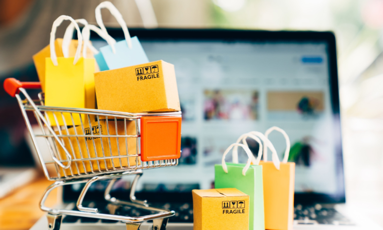 Shopping cart with packages and shopping bags in front of an e-commerce website, representing online retail and order fulfillment