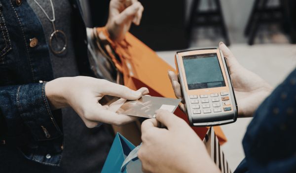 Customer paying with a card at a POS terminal, representing secure payment processing and retail transactions